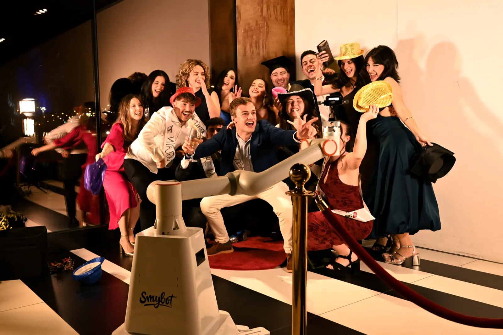 Graduados celebrando ante el Glambot de Smybox en la alfombra roja
