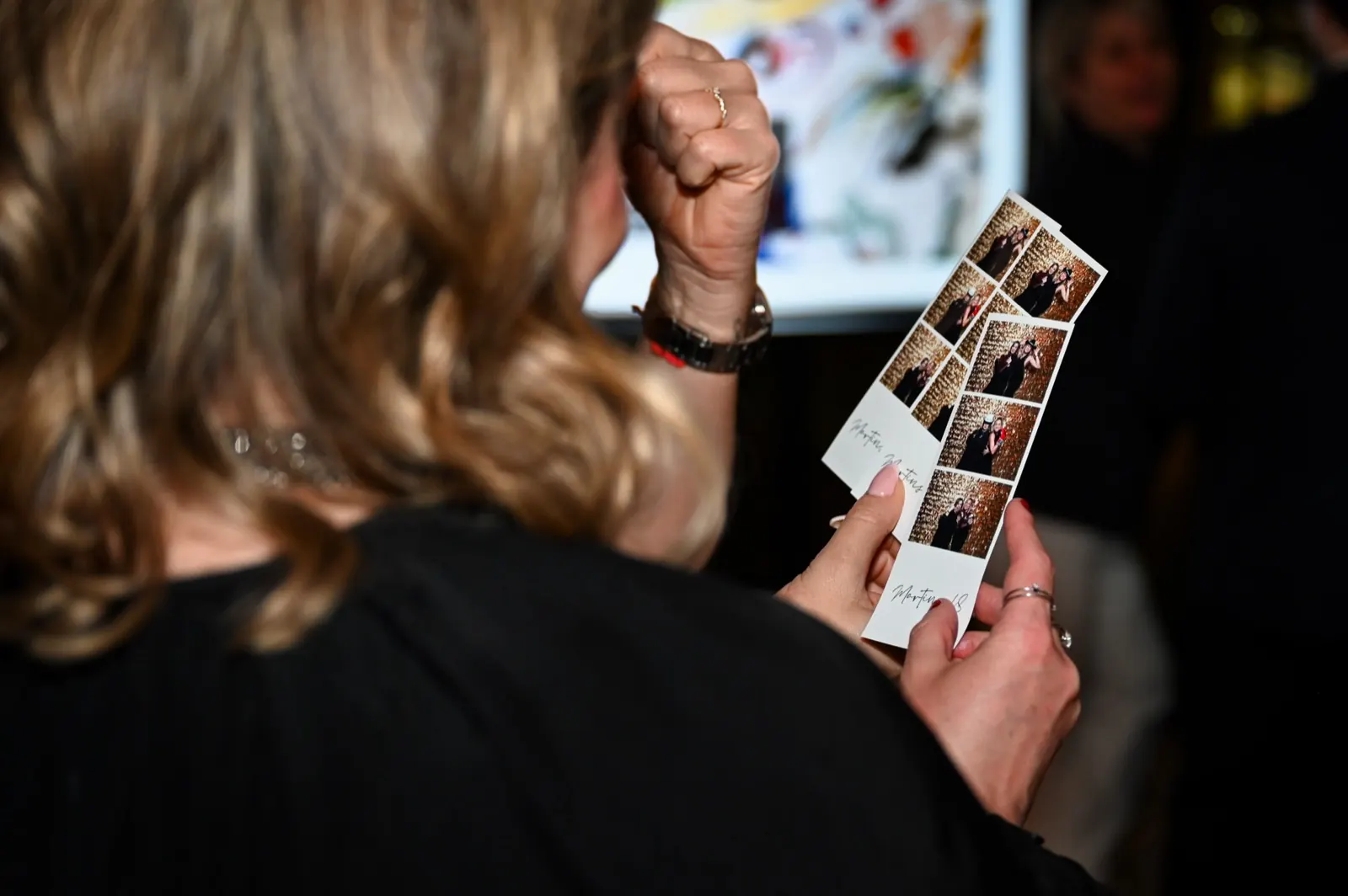 Una invitada mirando sus fotos impresas durante un evento